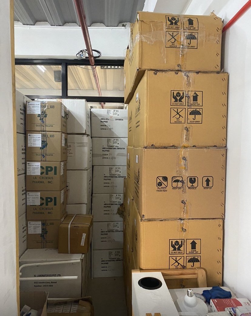 Bulk boxes of medicine stacked in Rojanzar Pharmacy storage